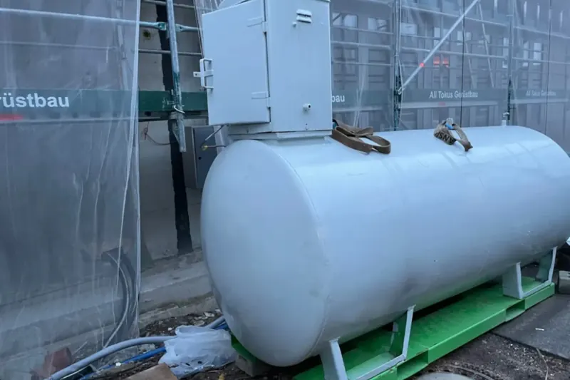 Doppelwandiger externer Heizöltank mit Armaturenschrank neben einem eingerüsteten Gebäude