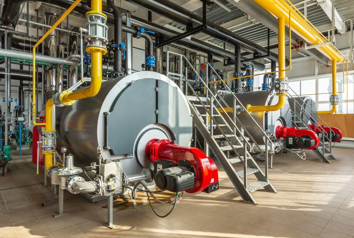 Grosse industrielle Dampferzeuger-Anlage von Swiss Energy Group in einer Werkshalle mit Gasleitungen